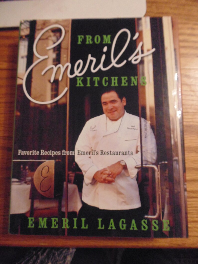 May include: A cookbook titled "From Emeril's Kitchen" featuring a photo of Emeril Lagasse in a chef's coat. The cover is black with white and green text. The book promises favorite recipes from Emeril's Restaurants.