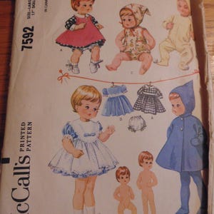Puede incluir: Patrón de costura McCall's 7592 para una muñeca de 43 cm. El patrón incluye instrucciones para hacer un vestido, un abrigo, un gorro y un pantalón. El patrón está impreso en un fondo blanco con un borde azul.