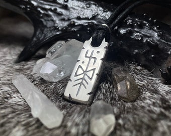 May include: A silver pendant with a geometric design hangs from a black cord. The pendant is surrounded by clear quartz crystals.