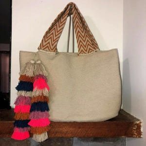 cartera wayuu con diseno de ojo turco y pom pompones