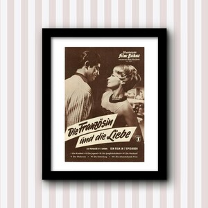 Op de afbeelding: Een vintage filmposter in een zwart frame met een sepia-kleurige afbeelding van een man en een vrouw die elkaar aankijken. De poster is voor een film genaamd "Die Französin und die Liebe", een film in de Duitse taal. De tekst op de poster luidt "Ein Film in 7 Episoden".