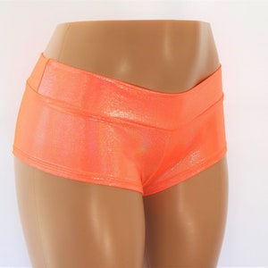 May include: A pair of bright orange, shiny shorts with a high waist and a V-shaped waistband.
