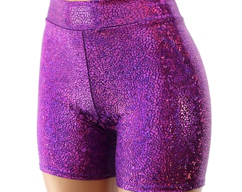 Può includere: Pantaloncini a vita alta in una vibrante tonalità viola metallizzato caratterizzati da una distinta texture screpolata simile a un mosaico su tutta la superficie. Il capo presenta una silhouette aderente con una fascia in vita.