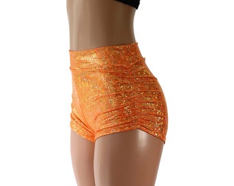 Shorts ajustados de talle alto fruncidos en color naranja neón y dorado, confeccionados en spandex holográfico brillante. Tallas para niños, adultos y tallas grandes. Laterales fruncidos.