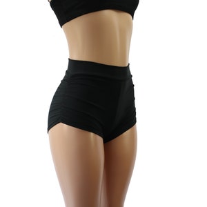 Könnte beinhalten: Schwarze, hochgeschnittene Shorts mit einem gerafften Detail auf der Vorderseite. Die Shorts sind aus einem dehnbaren Stoff gefertigt und haben eine bequeme Passform.