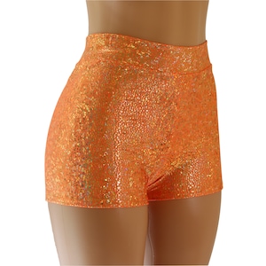 Może przedstawiać: Pomarańczowe szorty z wysokim stanem, z błyszczącym, tęczowym wykończeniem. Szorty wykonane są z elastycznego, wygodnego materiału.