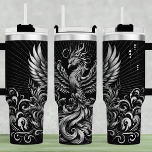 Könnte beinhalten: Drei Edelstahlbecher mit schwarzem Hintergrund und einem silbernen Phönix-Design. Der Phönix ist von wirbelnden floralen Mustern umgeben.