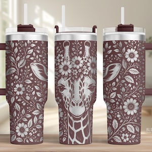 Può includere: Un set di tre bicchieri isolati con un design a giraffa. I bicchieri sono di colore bordeaux scuro con un motivo floreale e un volto di giraffa. Ogni bicchiere ha un manico, un coperchio e una cannuccia.