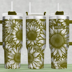May include: A stainless steel tumbler with a sunflower design. The tumbler has a green handle, lid, and straw. The body of the tumbler is covered in a pattern of white sunflowers on a green background. The Stanley logo is visible on the side.