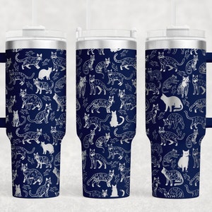 May include: Three stainless steel tumblers with a navy blue background and a white cat pattern. The tumblers have a lid and a handle.