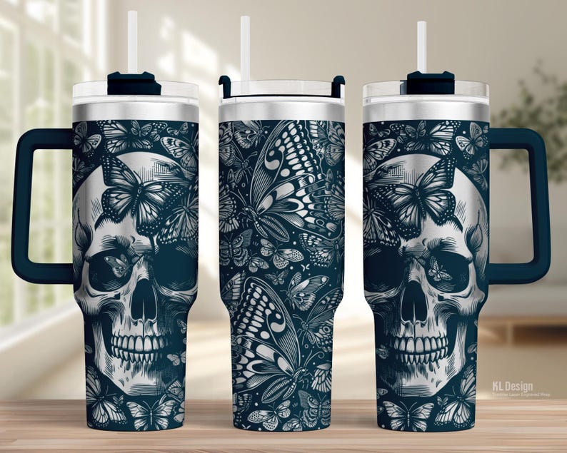 May include: A stainless steel tumbler with a dark blue handle and lid. The tumbler features a skull design with butterflies in a detailed black and white illustration. The tumbler includes a white straw.