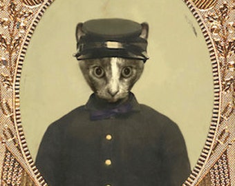 May include: A vintage-style photograph of a cat wearing a military uniform and a cap. The photo is framed in a gold and red ornate frame with a scalloped edge. The text "by Muriel McDonald" is printed below the frame.