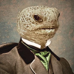May include: A vintage-style portrait features a turtle's head superimposed on a person in formal attire. The turtle's head is a mottled tan color, and it wears a gray suit with a black lapel and a green ascot. The background is a muted, textured gray.