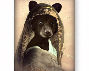 May include: A black bear wearing a gold and green patterned head covering. The bear is looking directly at the camera. The background is a light brown with a faded, vintage look.