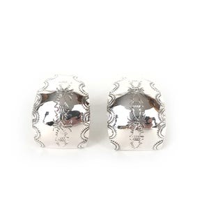 May include: A pair of silver hoop earrings with a decorative design. The earrings are made of sterling silver and have a polished finish.