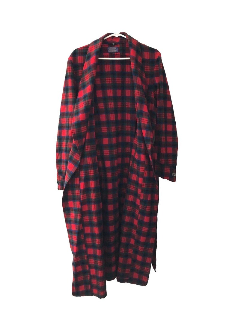 May include: A long, open-front robe featuring a red and dark navy blue plaid pattern. The garment has long sleeves with buttoned cuffs, a wide shawl collar, and a tie-waist closure. The fabric displays a consistent checkered design throughout.
