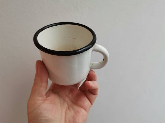 Vintage enameled mug, white enamel wäre drinking cup with black rim, early eighties