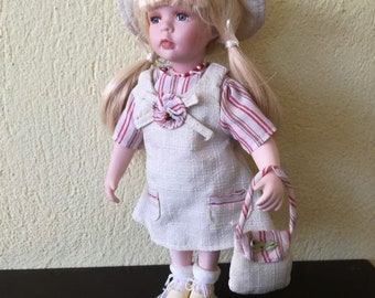 Vintage porcelain doll, blond porcelain doll in pony tails, beige dress, hat and shoes,  vintage doll on metal stand, early eighties