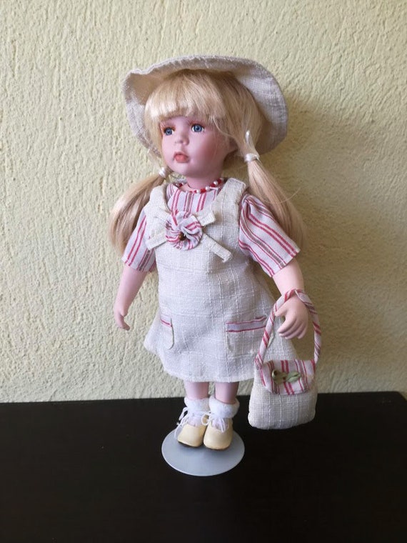 Vintage porcelain doll, blond porcelain doll in pony tails, beige dress, hat and shoes,  vintage doll on metal stand, early eighties