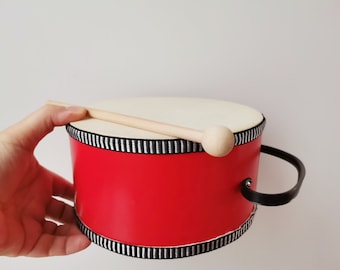 Vintage toy drum, red and white toy drum with wooden drumstick and black holder band, vintage toys, membrane and metal drum