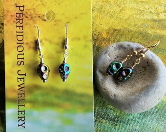 Rainbow goth skull earrings - iridescent glass dangle small skulls - colourful Halloween. Clip on earring available.