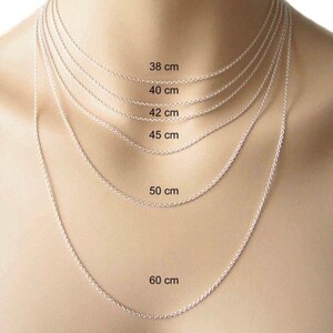 May include: A silver chain necklace in various lengths, displayed on a model's neck. The lengths are labeled in centimeters: 38 cm, 40 cm, 42 cm, 45 cm, 50 cm, and 60 cm.