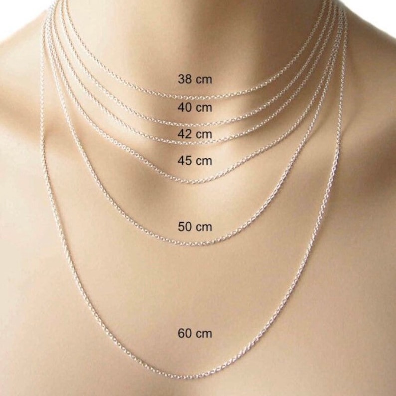 May include: A silver chain necklace in various lengths, displayed on a model's neck. The lengths are labeled in centimeters: 38 cm, 40 cm, 42 cm, 45 cm, 50 cm, and 60 cm.