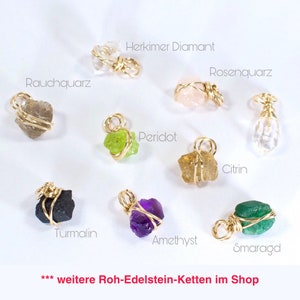 May include: A collection of nine raw gemstone pendants wrapped in gold wire. The gemstones include Herkimer diamond, rose quartz, smoky quartz, peridot, citrine, tourmaline, amethyst, emerald, and a clear quartz.  *** weitere Roh-Edelstein-Ketten im Shop