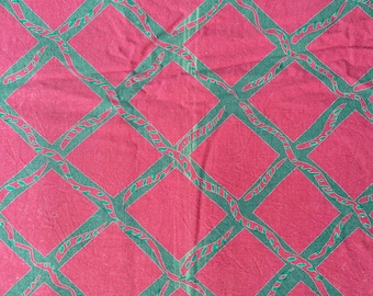 May include: A pink fabric with a repeating pattern of green diamond shapes. The diamonds are outlined in a darker green and have a wavy, organic design.