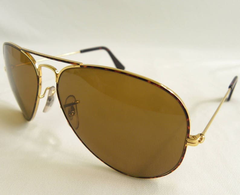 K&ouml;nnte beinhalten: Goldgerahmte Aviator-Sonnenbrille mit braunen Gl&auml;sern und einem Schildpattgestell.
