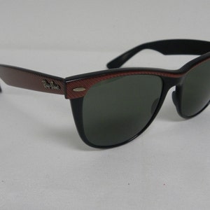 May include: Black sunglasses with red and black patterned frames. The sunglasses have dark lenses.
