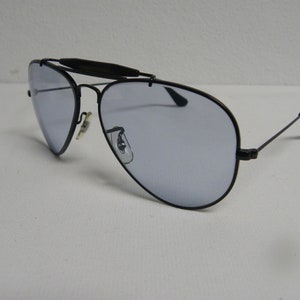 May include: Black aviator sunglasses with a metal frame and blue tinted lenses.
