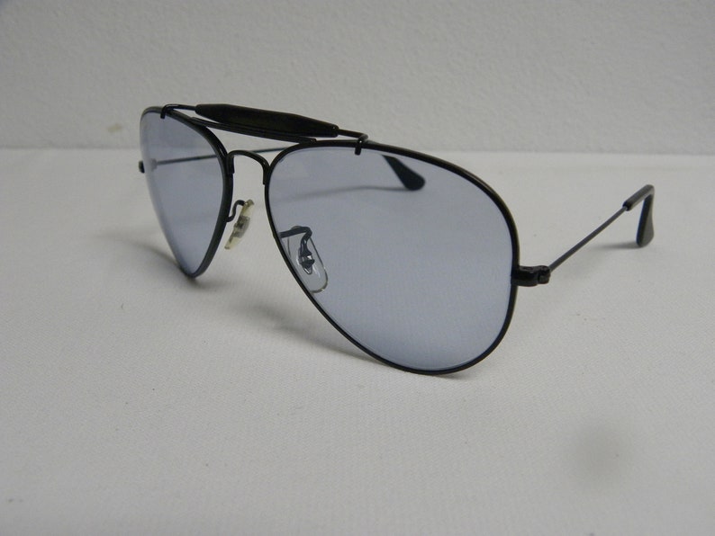 May include: Black aviator sunglasses with a metal frame and blue tinted lenses.