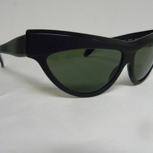 Puede incluir: Gafas de sol negras de ojo de gato con lentes verde oscuro.