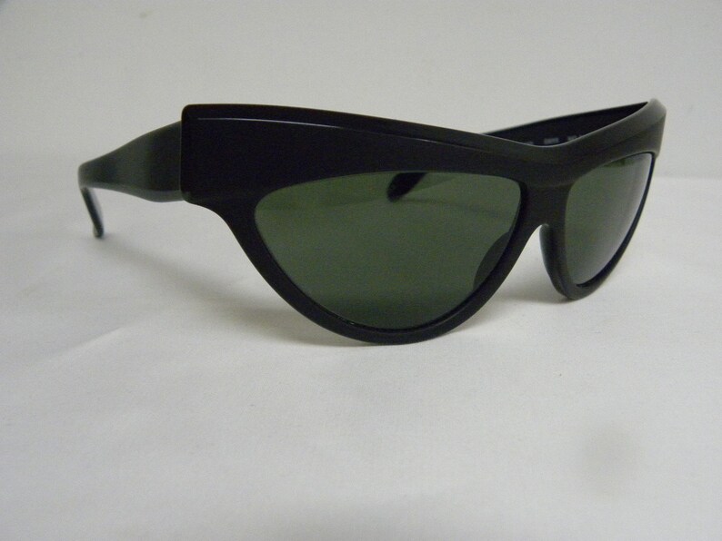 Puede incluir: Gafas de sol negras de ojo de gato con lentes verde oscuro.