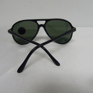 May include: Black aviator sunglasses with green lenses. The sunglasses have a metal frame and are in good condition.