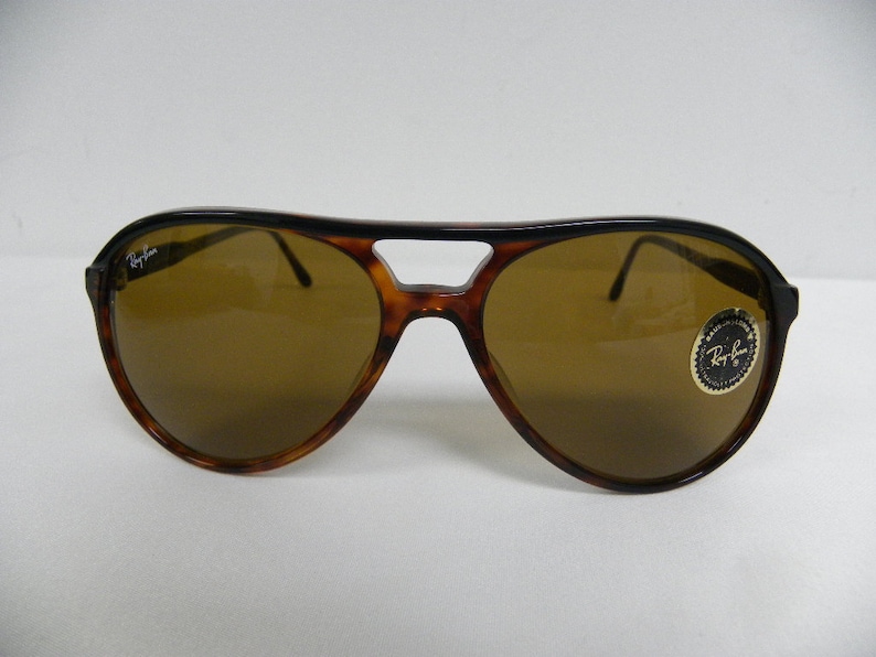 Puede incluir: Un par de gafas de sol aviador de carey marr&oacute;n con lentes marrones. Las gafas tienen el logotipo de Ray-Ban en la lente izquierda y una pegatina de Ray-Ban en la lente derecha.