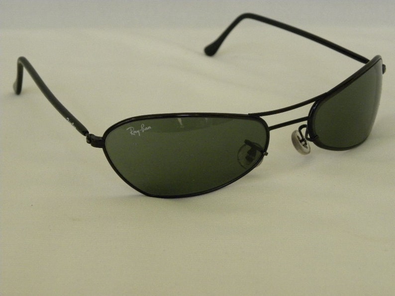 May include: Black Ray-Ban sunglasses with green lenses. The sunglasses have a metal frame and are in good condition.