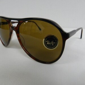 Puede incluir: Gafas de sol aviador de carey marr&oacute;n con lentes marrones. Las gafas tienen el logotipo de Ray-Ban en la lente derecha.