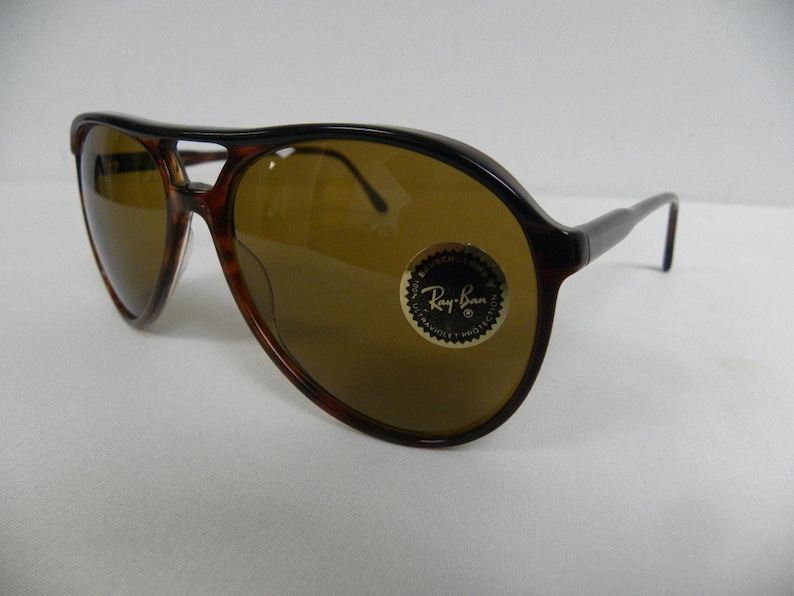 Puede incluir: Gafas de sol aviador de carey marr&oacute;n con lentes marrones. Las gafas tienen el logotipo de Ray-Ban en la lente derecha.