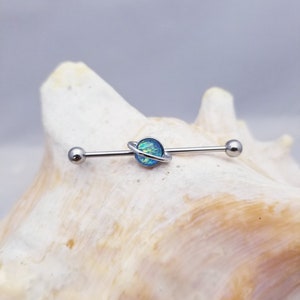 14G industrial barbell with imitation blue opal planet charm