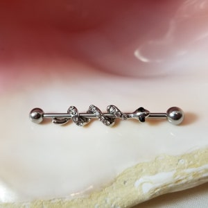 14G industrial barbell with snake charm adorned with clear CZ gems