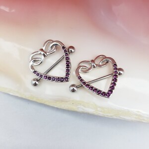 Pair of 14G purple CZ lined heart shaped nipple rings with bow