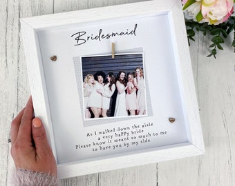 May include: White picture frame with a photo of a group of women in white dresses. The frame has the text "Bridesmaid" and a poem that reads "As I walked down the aisle a very happy bride Please know it meant so much to me to have you by my side."
