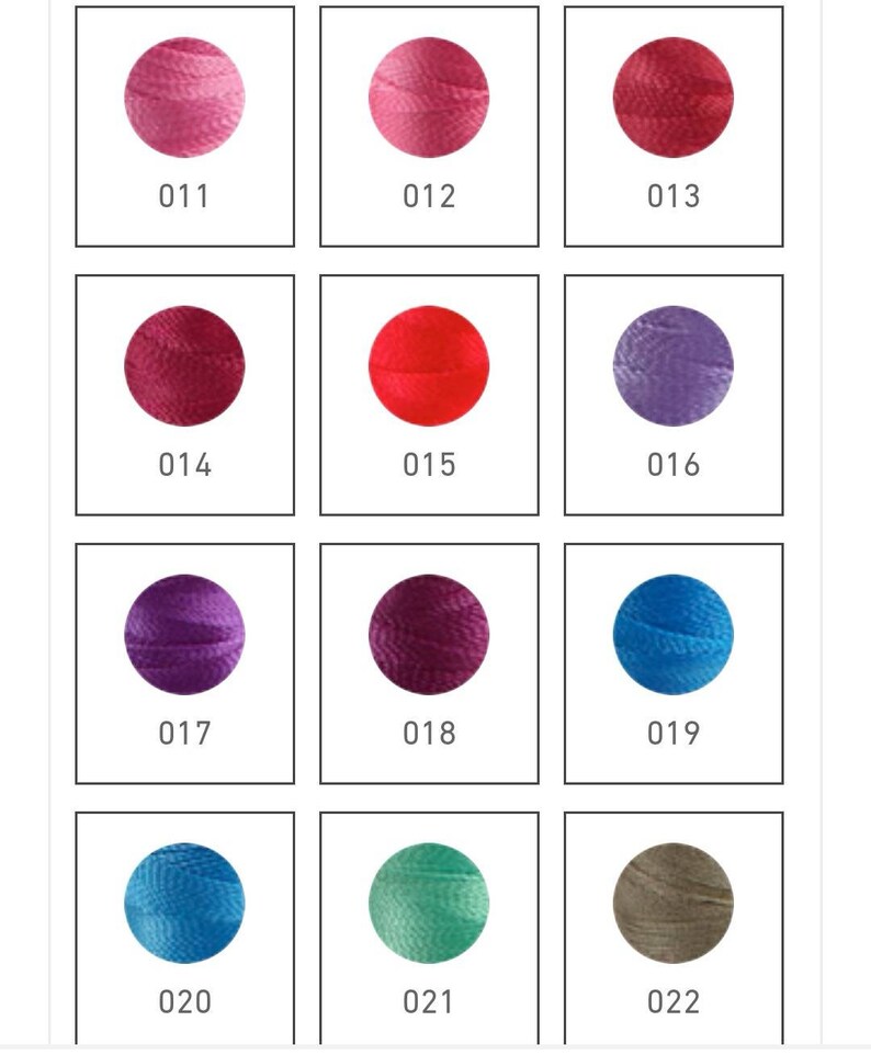 Op de afbeelding: Een verzameling van 12 kleine garenbollen in verschillende kleuren, waaronder roze, rood, paars, blauw en groen. Elke bol is gemarkeerd met een nummer van 011 tot 022.