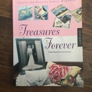 May include: A pink book titled "Treasures Forever" with the subtitle "Crafts for Keeping Family Memories" by Connie Sheerin & Janet Pensiero. The cover features a vintage photo of a bride, a handkerchief, and a floral fabric.