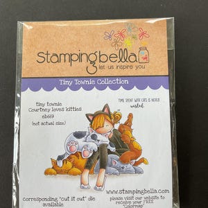May include: A clear plastic package containing a Tiny Townie Collection stamp set. The illustration features a girl with cat ears surrounded by several cats. Text includes "Courtney loves kitties" and "TIME SPENT WITH CATS IS NEVER wasted."