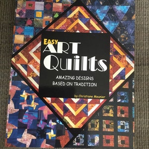 May include: Book cover with the title "EASY ART Quilts" in white text on a black background. The subtitle is "AMAZING DESIGNS BASED ON TRADITION" in white text. The author's name, "Christiane Meunier", is in smaller white text below the subtitle. The cover features a colorful patchwork quilt design.