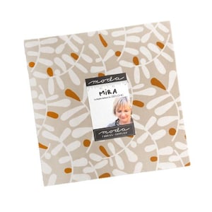 May include: A square fabric piece with a beige background and a repeating pattern of white and orange leaf-like shapes. A tag with the name "MIRA" and a woman's image is attached to the fabric. The tag also includes the "moda FABRICS + SUPPLIES" logo.