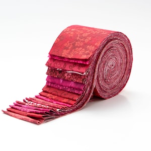 May include: A roll of red and pink fabric with floral patterns. The fabric is rolled up and tied with a ribbon.